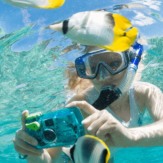 child taking photos of fish with an underwater camera