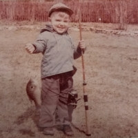 young child holding a fish on the line