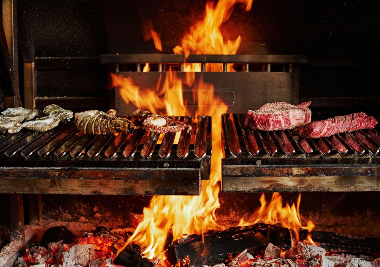 An open fire with steaks on it in Kindler in Islamorada.