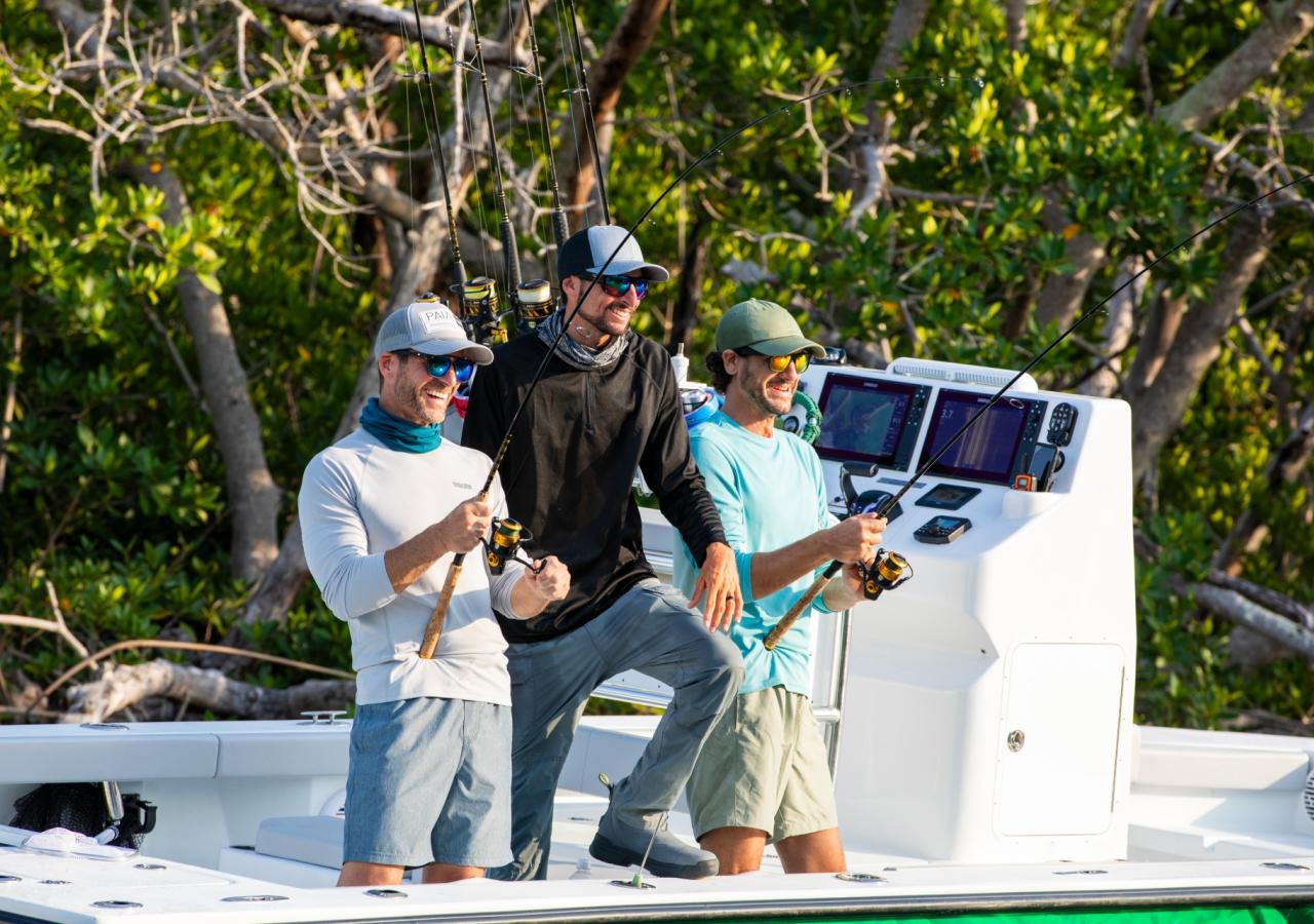 Three people fishing off of a boat