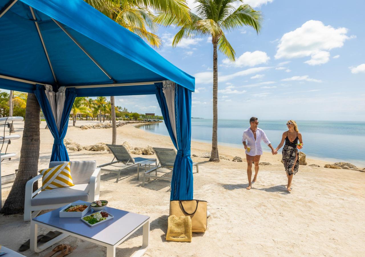 A couple walking on the beach at Three Waters Resort & Marina.
