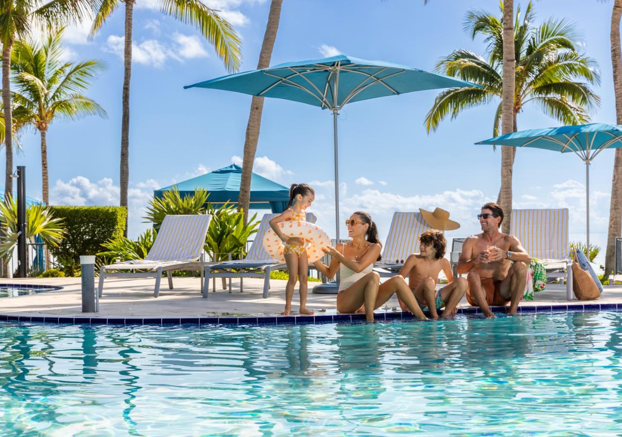 A family sitting by the pool at Three Waters Resort in Islamorada.