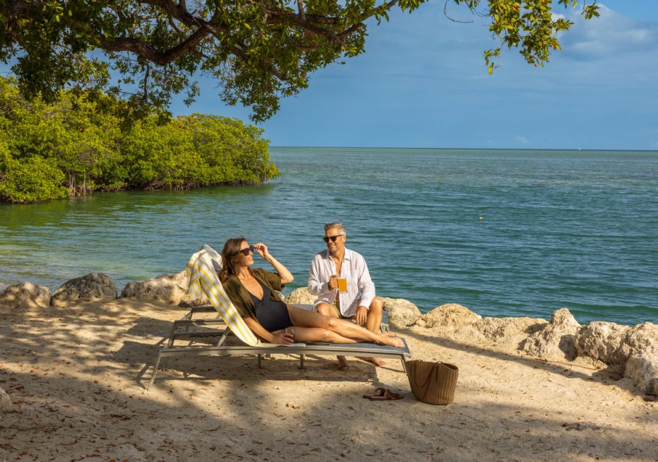 A couple sitting in the sun at the Cove at Three Waters in Islamorada, Florida.