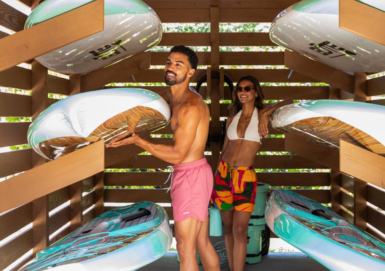 A couple getting paddleboards out of a shed at BOTE House Islamorada.