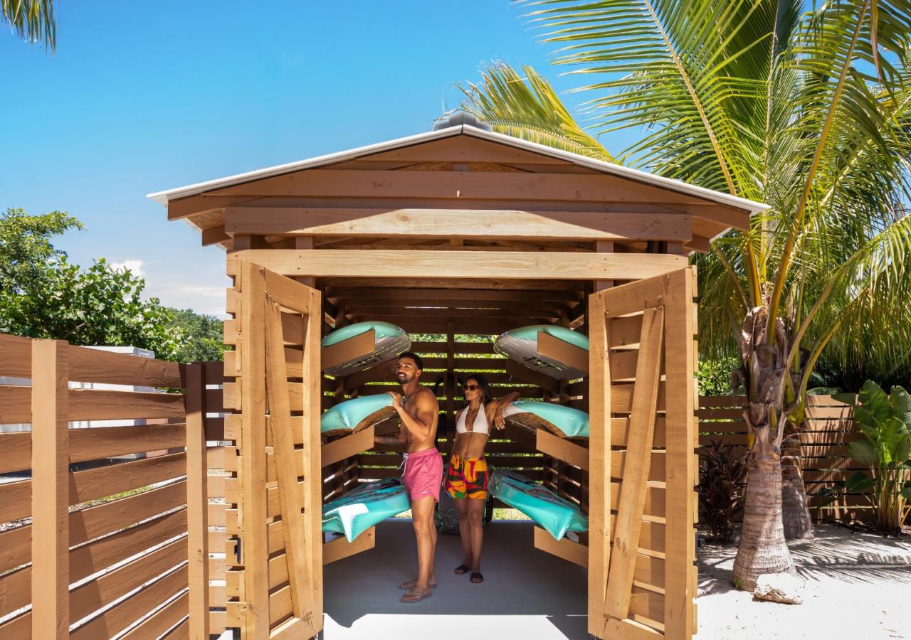 A couple getting paddleboards out of a shed at BOTE House Islamorada.