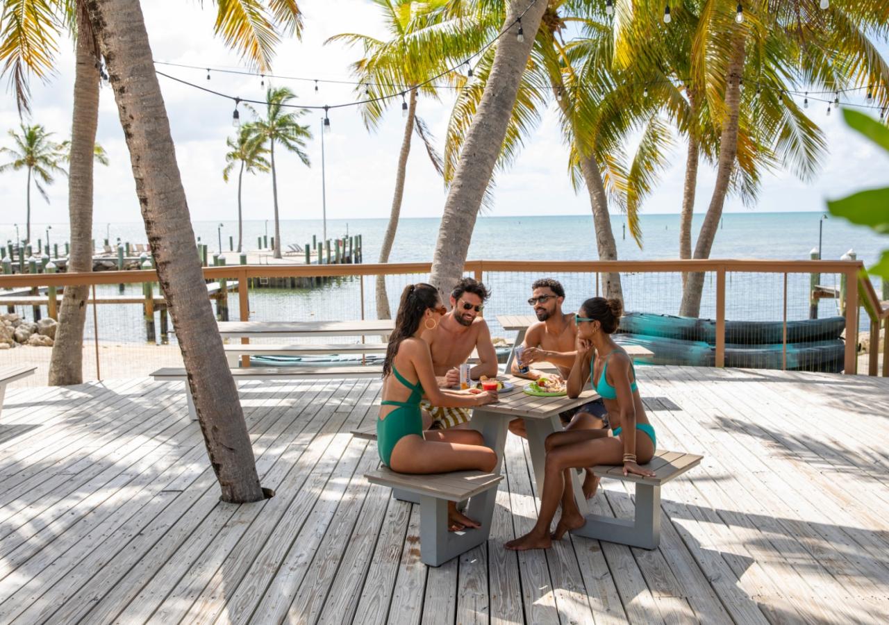 Friends sitting at a table by the ocean at La Siesta in the Florida Keys.