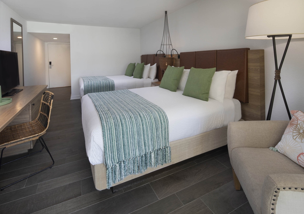 bedroom with two queen beds and a chair