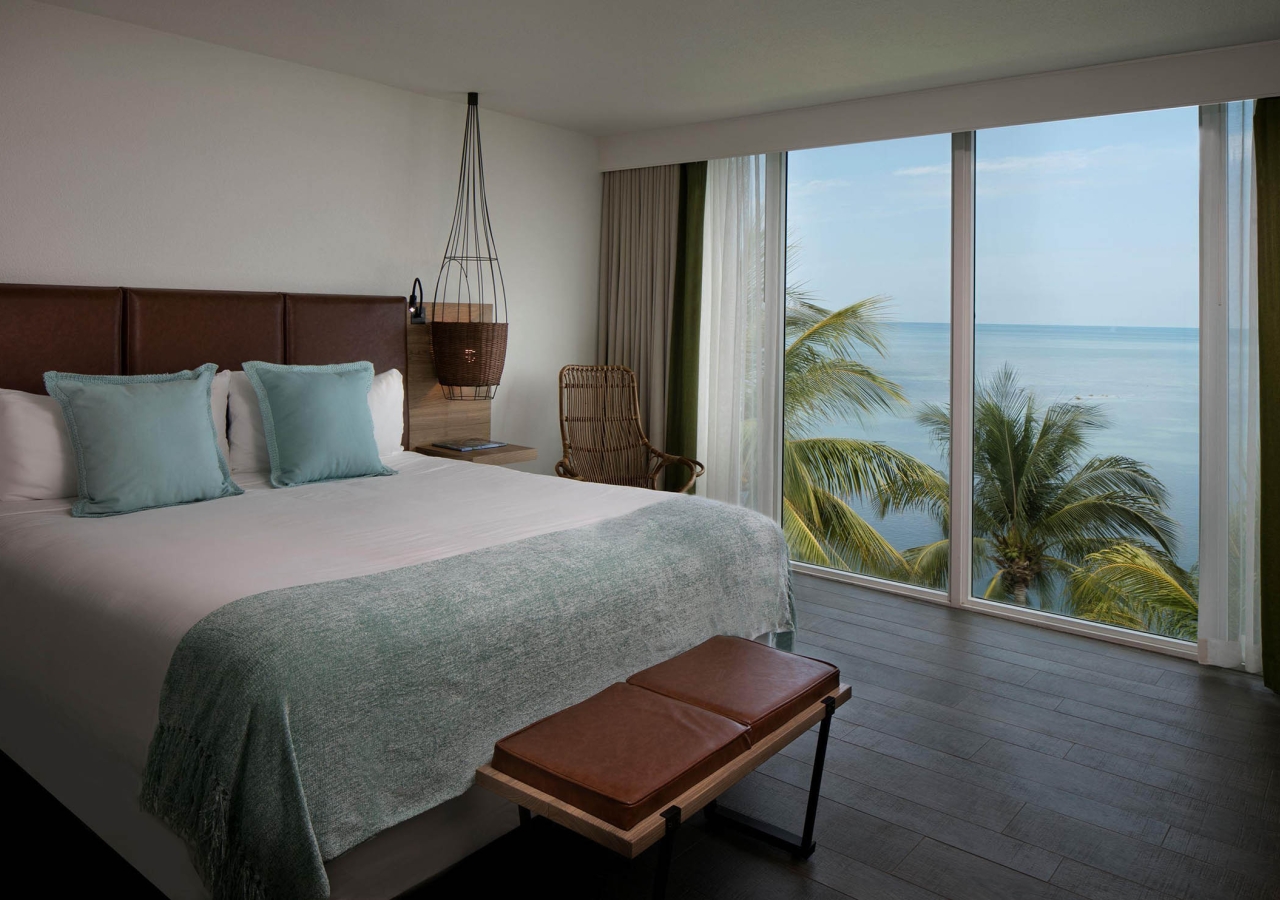 bedroom with large windows overlooking the ocean