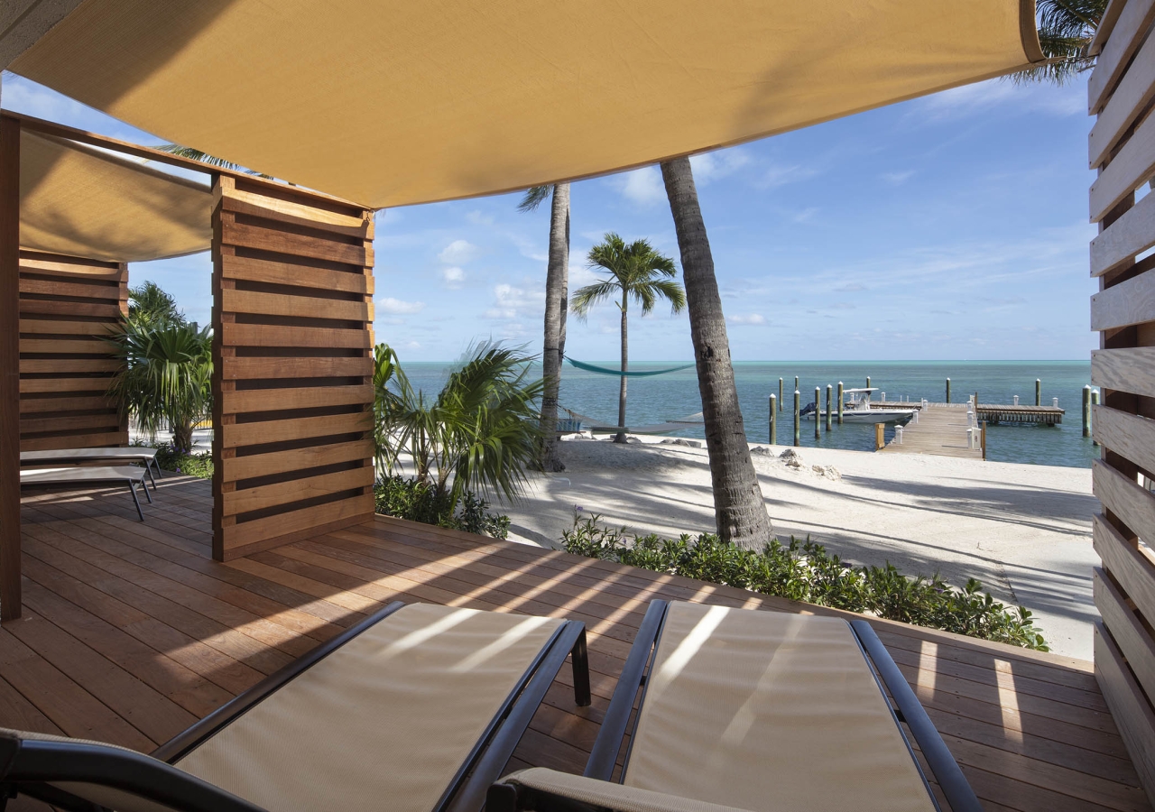 lounge chairs in enclosed lanai looking out into the ocean