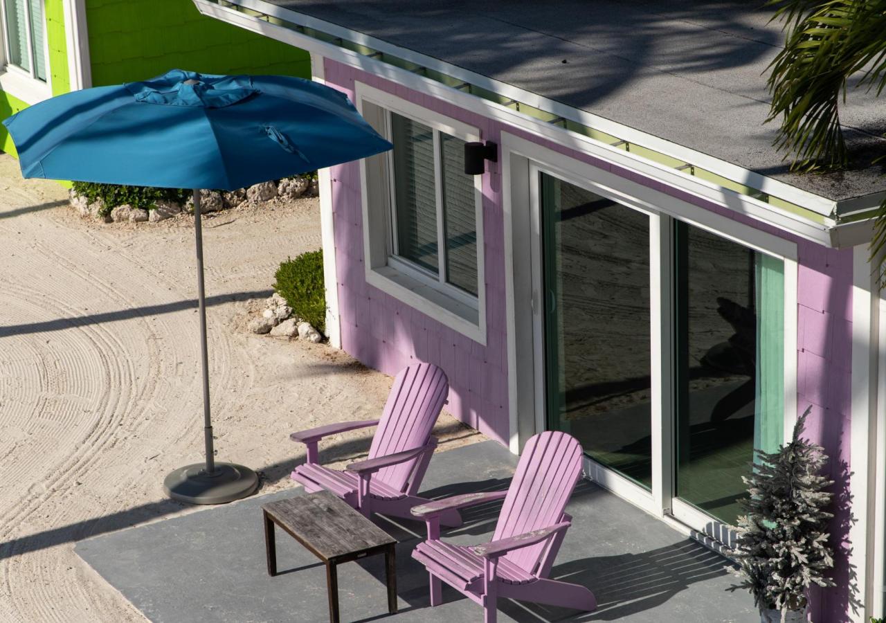 A purple beachfront cottage with two chairs at La Siesta Resort & Villas in Islamorada, Florida