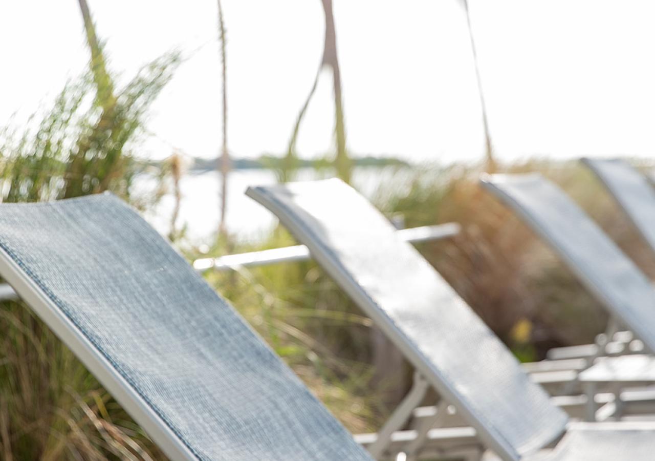 Chaise lounges with drinks next to them at Amara Cay in Islamorada, Florida.