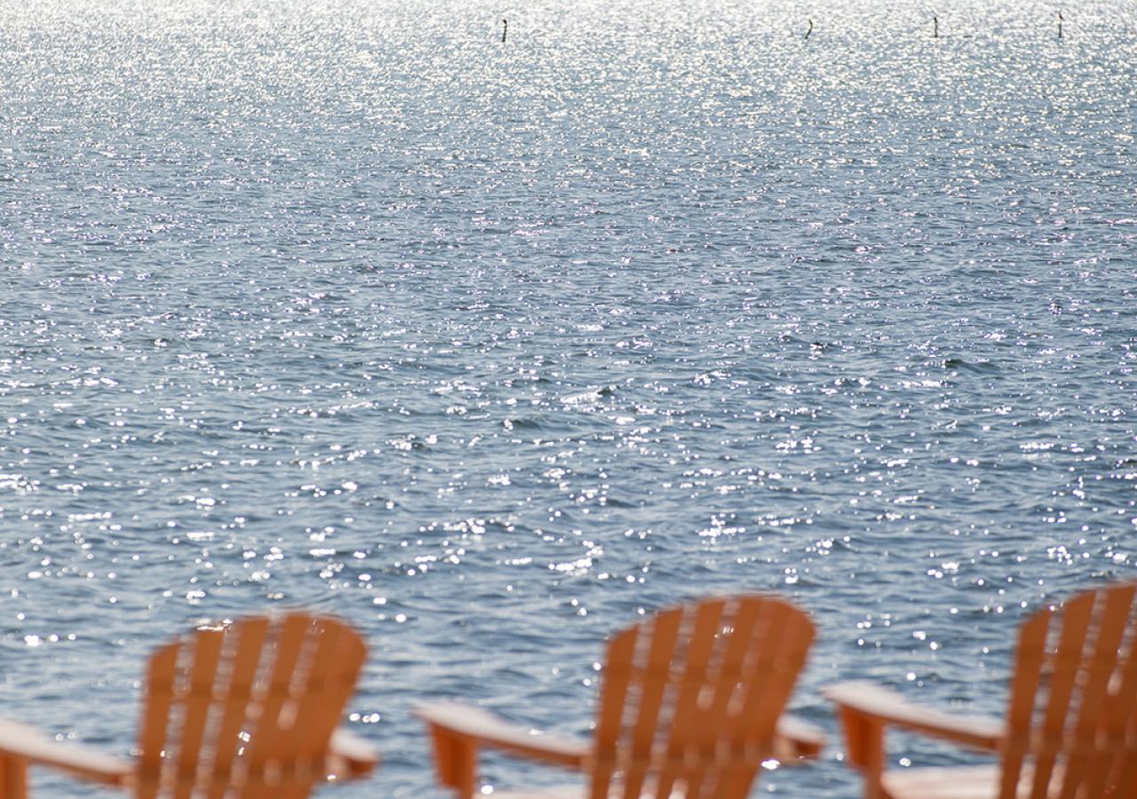 Coral Adirondack chairs next to the water at La Siesta in the Florida Keys.