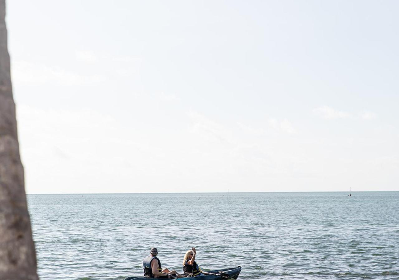 Two people kayaking near the beach at Three Waters Resort & Marina in the Florida Keys.