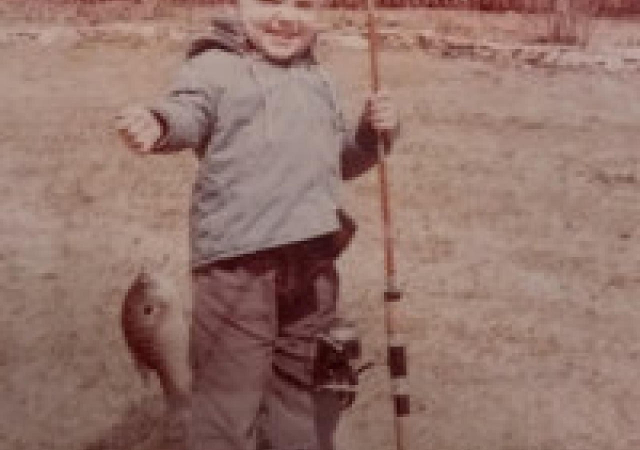 young child holding a fish on the line