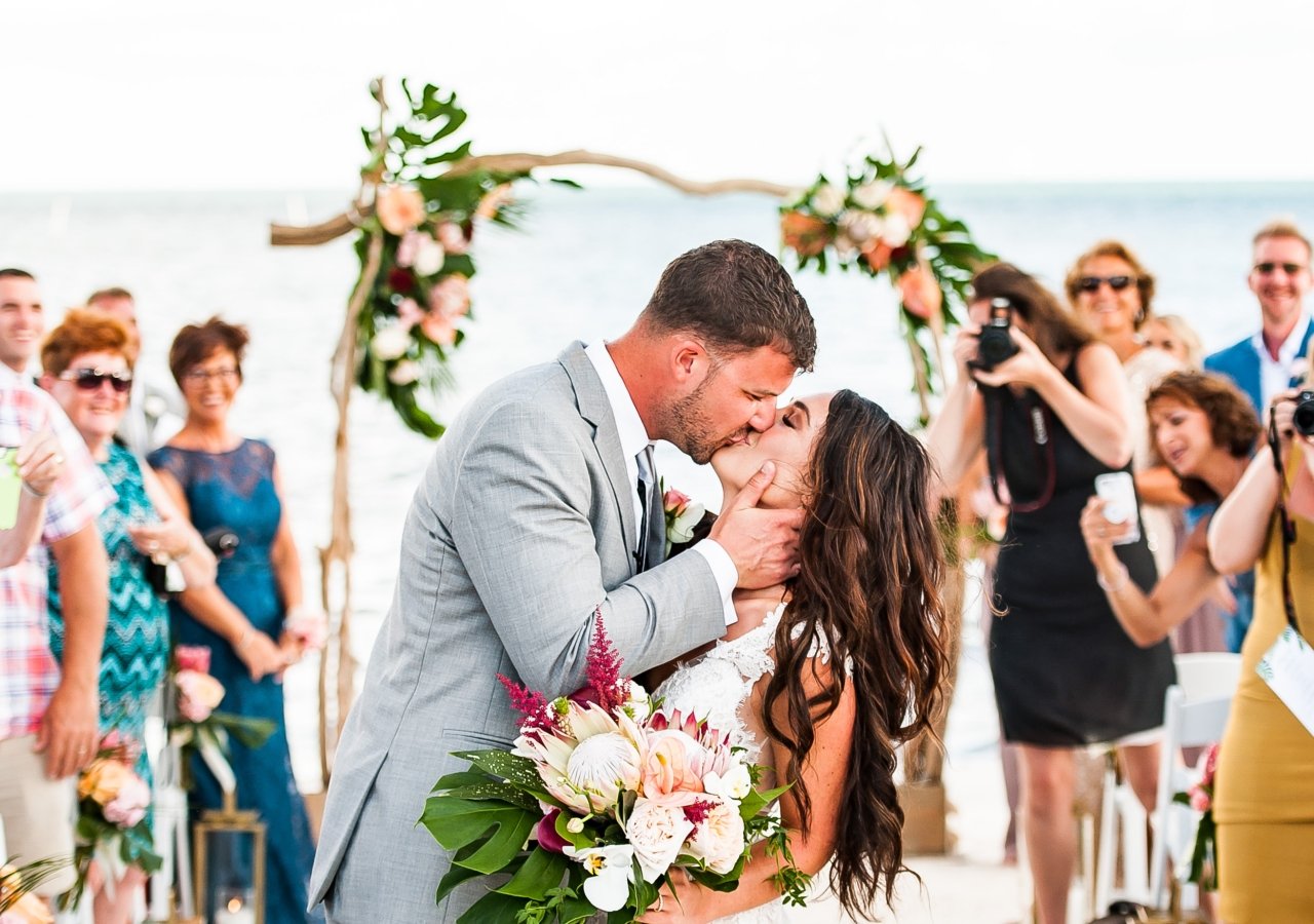 bride and groom kissing on the beach