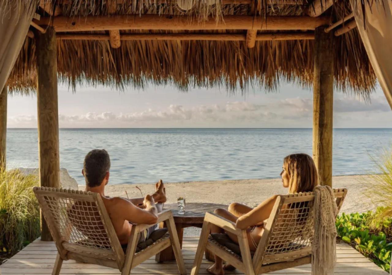 A couple sits at an oceanfront cabana
