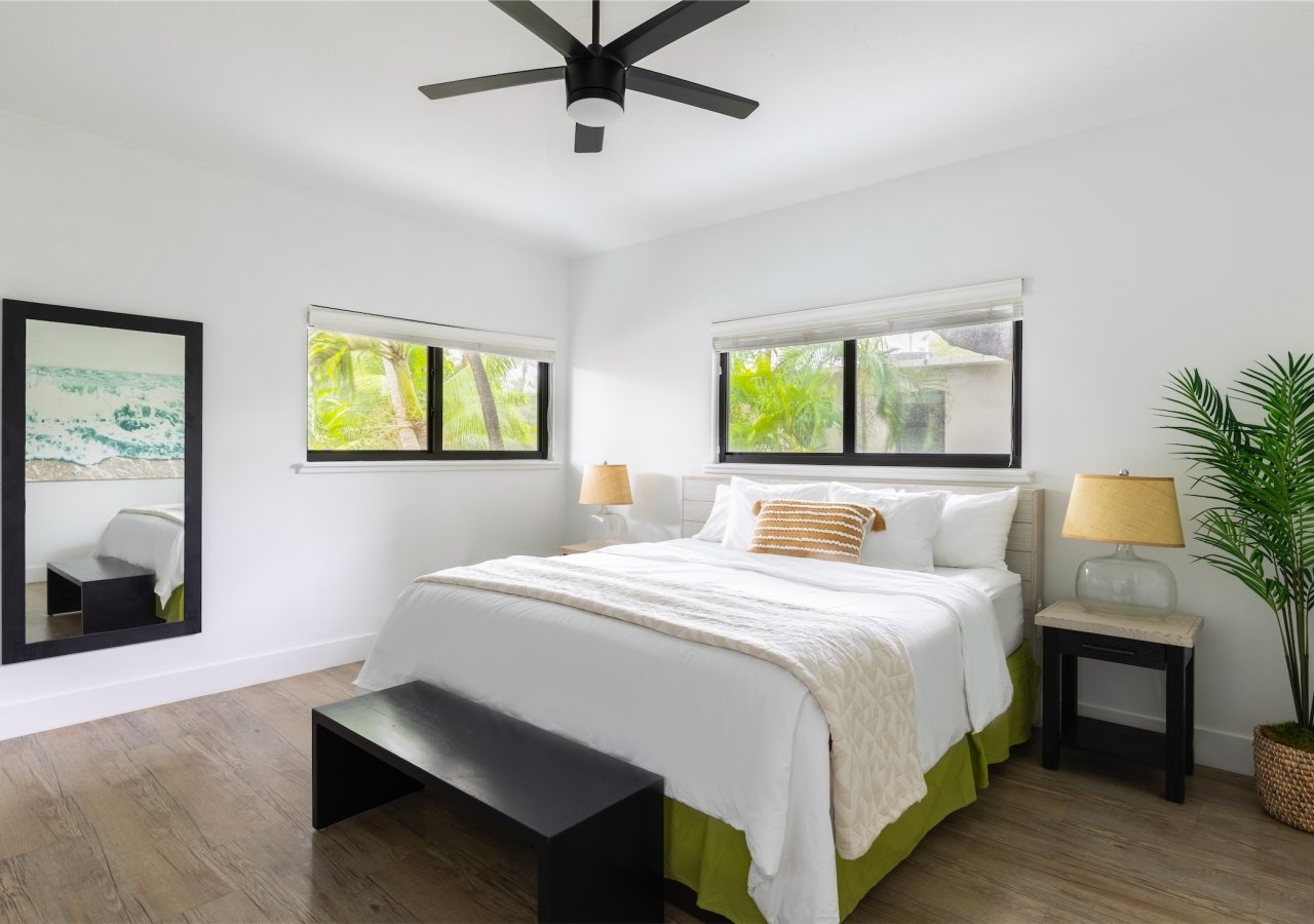 bedroom with bed and two bedside tables with a small bench at the foot of the bed