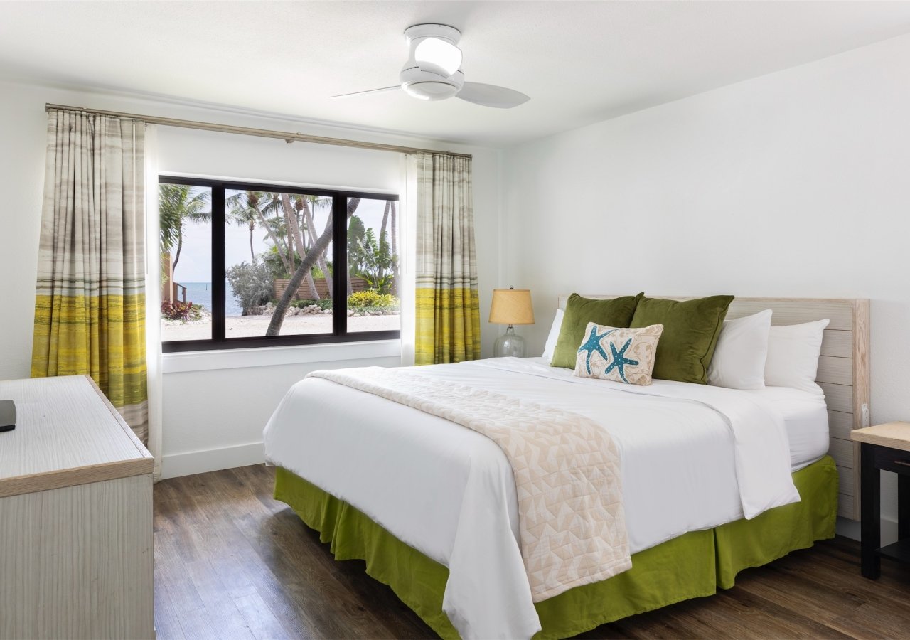 bedroom with large window overlooking the beach