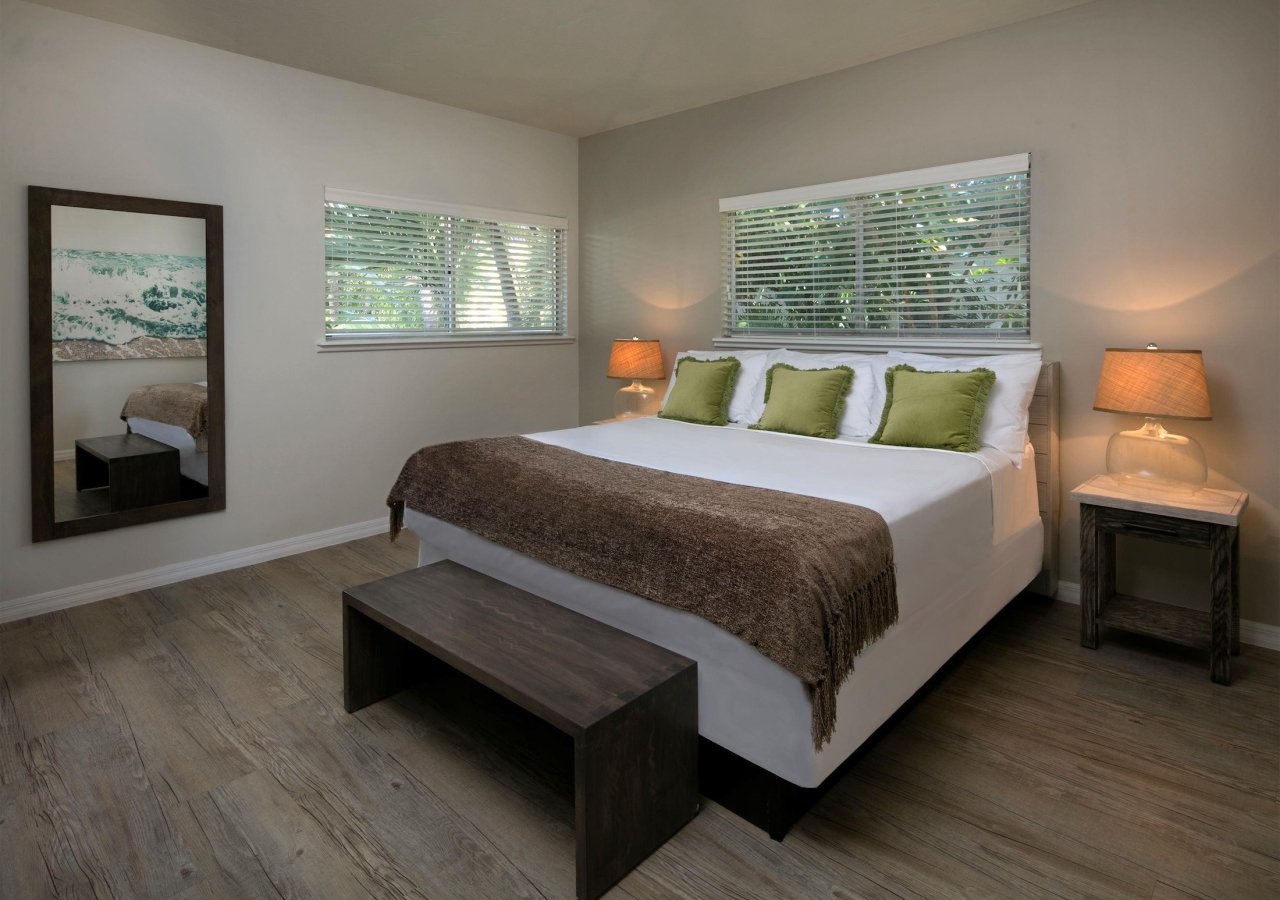 bedroom with two windows and a bench at the foot of the bed