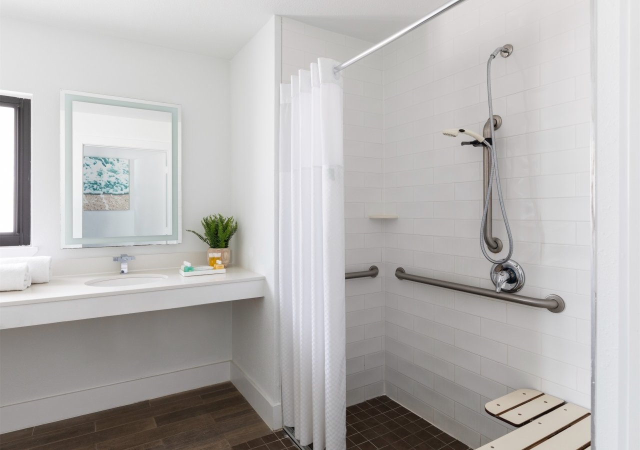 roll-in shower with grab bars and bench