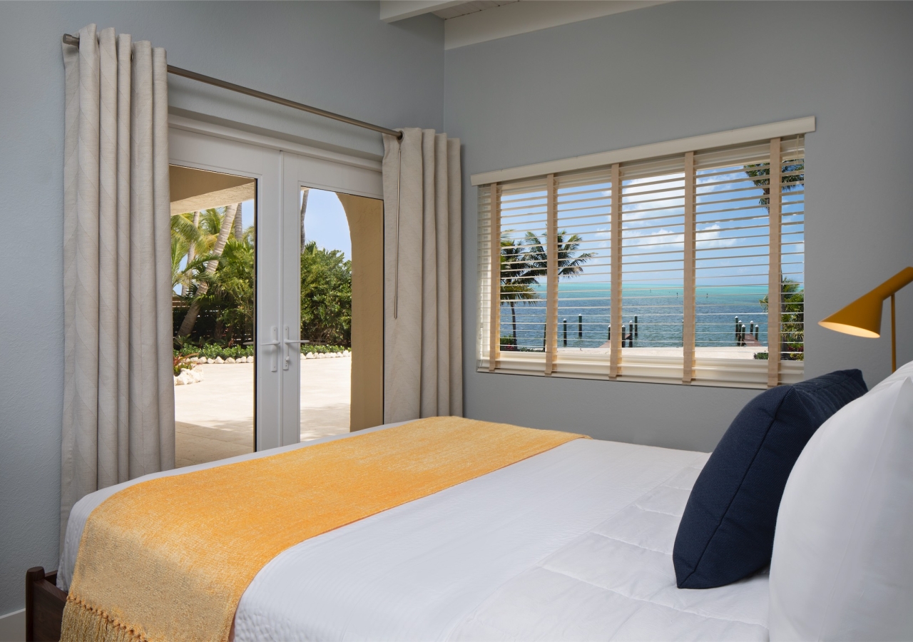 bedroom with patio door and view of beach