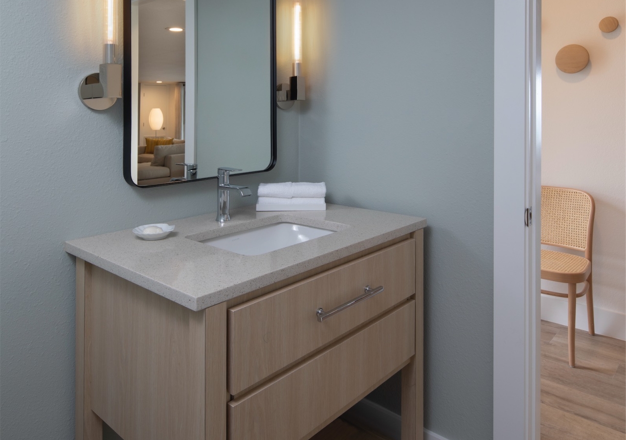 bathroom with small vanity and black framed mirror