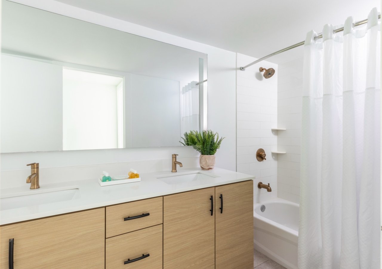 bathroom with long vanity and a shower with built in shelves