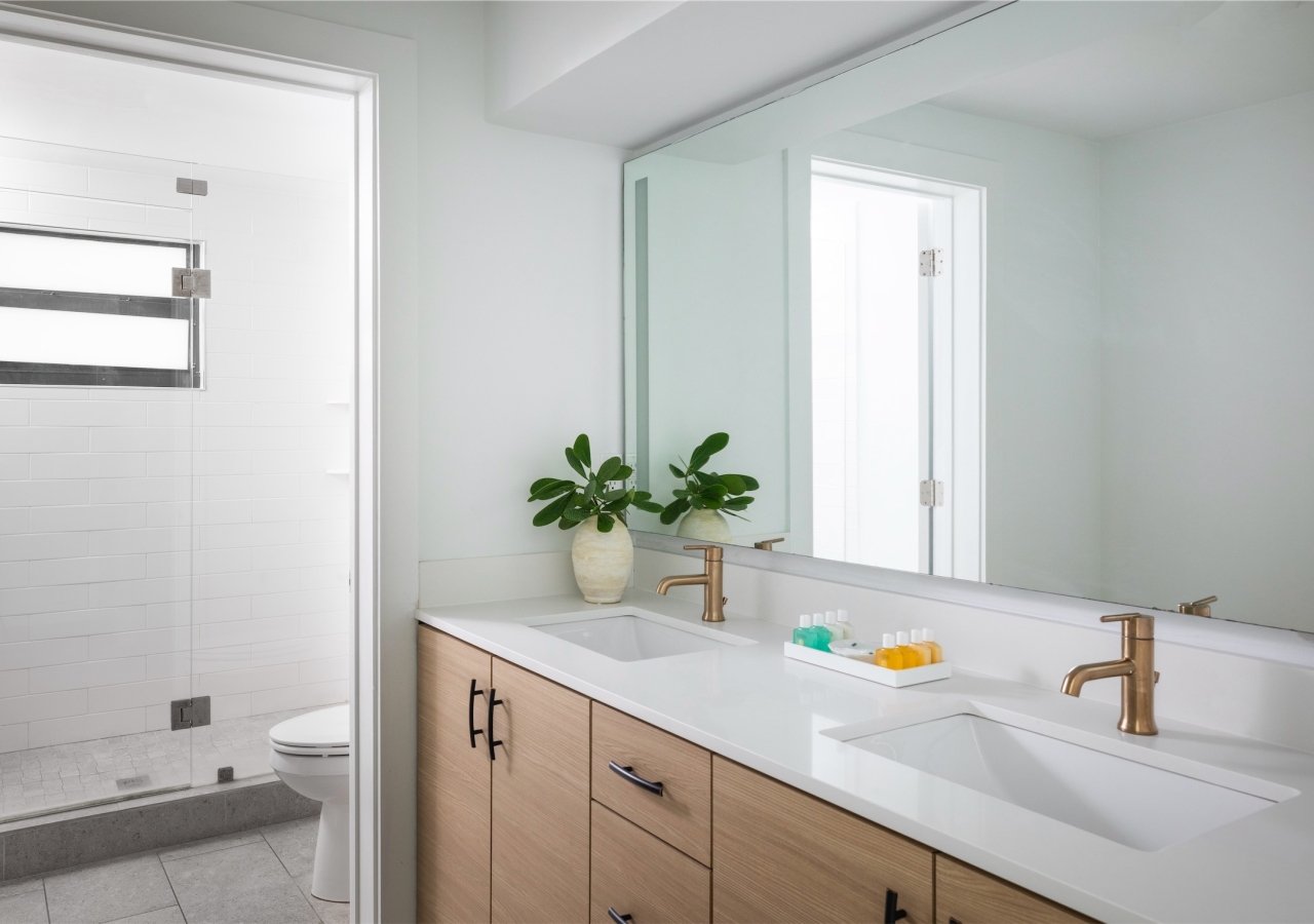 bathroom with twin sinks and a separate room for the walk-in shower and water closet