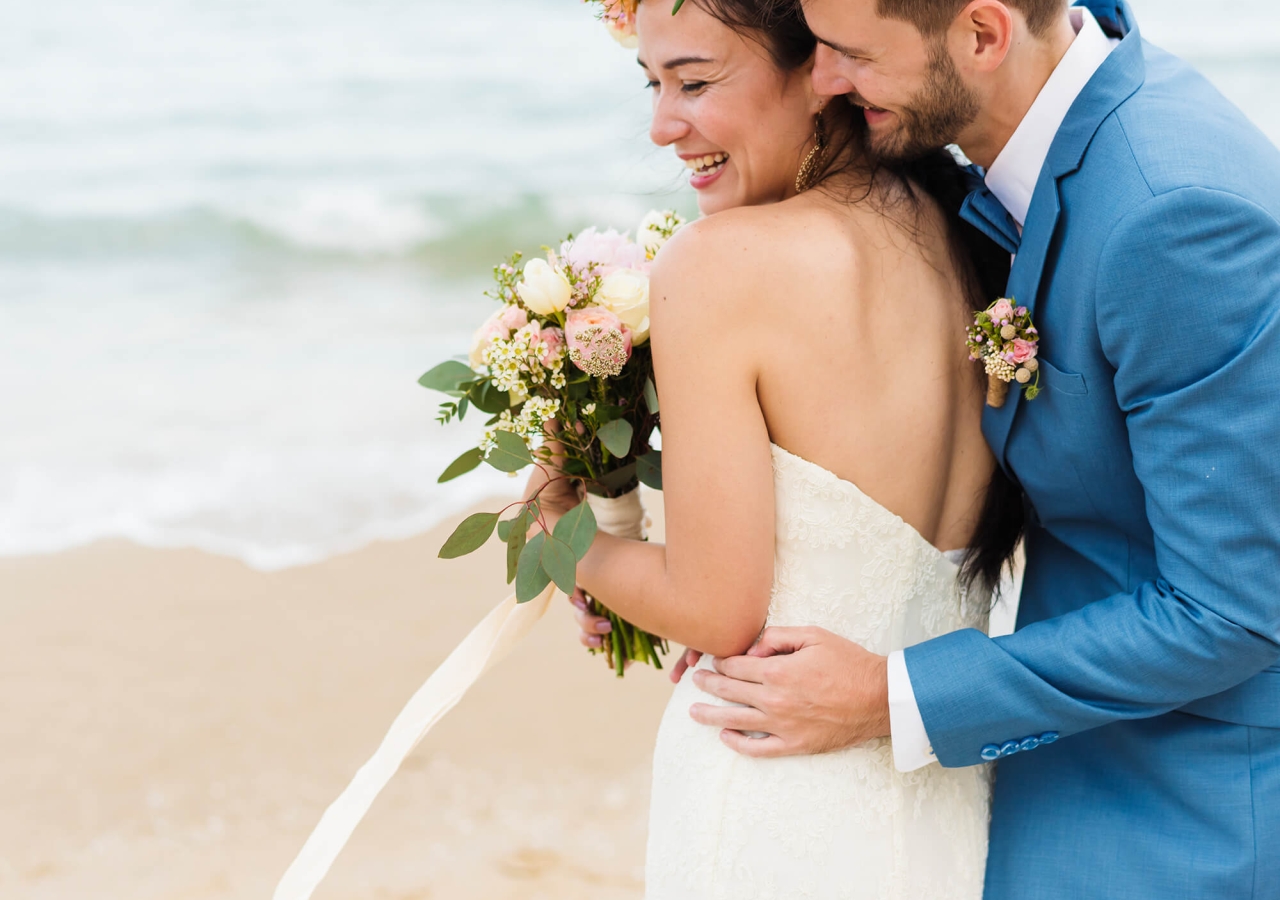 bride and groom kissing on the beach