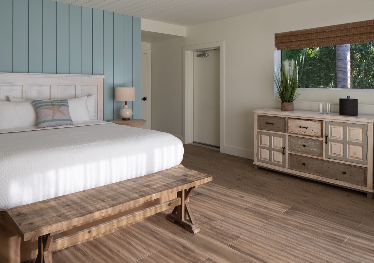 bedroom with dresser and bench at the foot of the bed