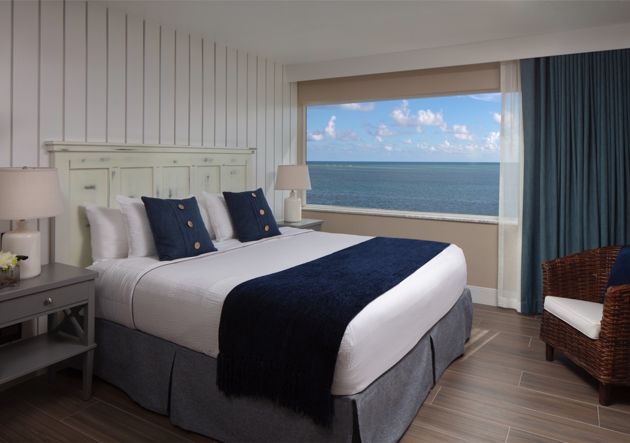 Bedroom with a large window with an ocean view