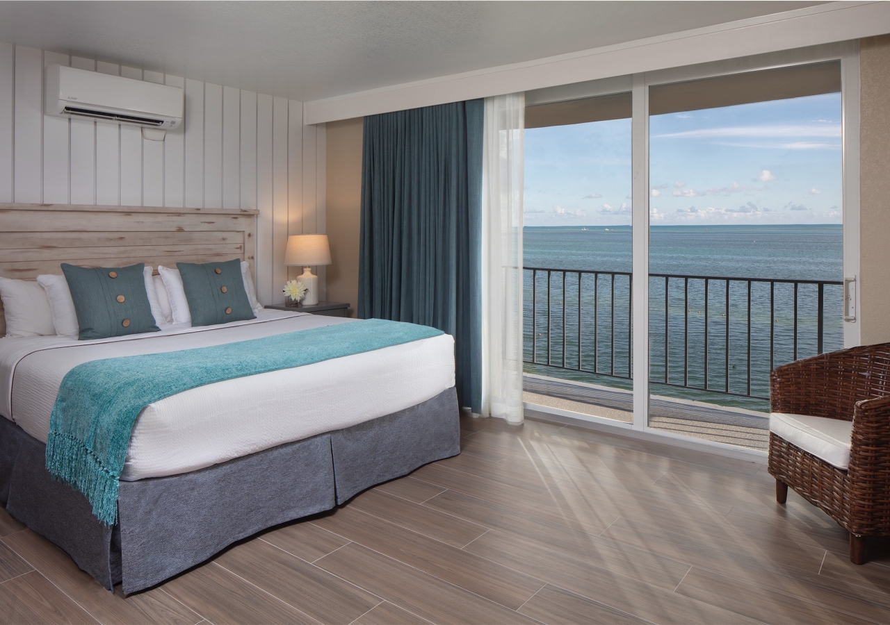 Bedroom with king bed and large balcony overlooking the ocean