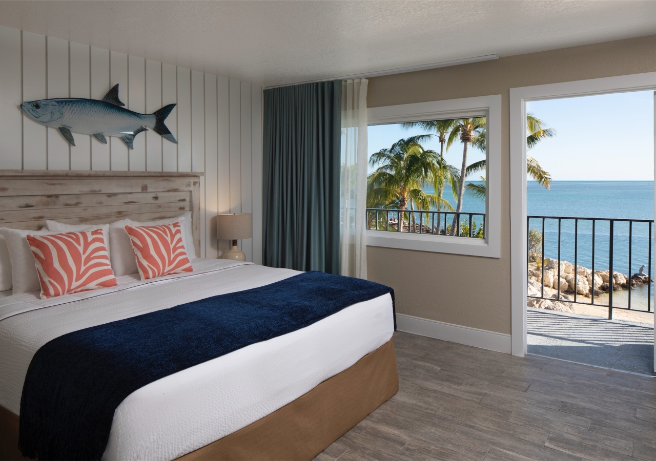 bedroom with open balcony door that leads to the beach