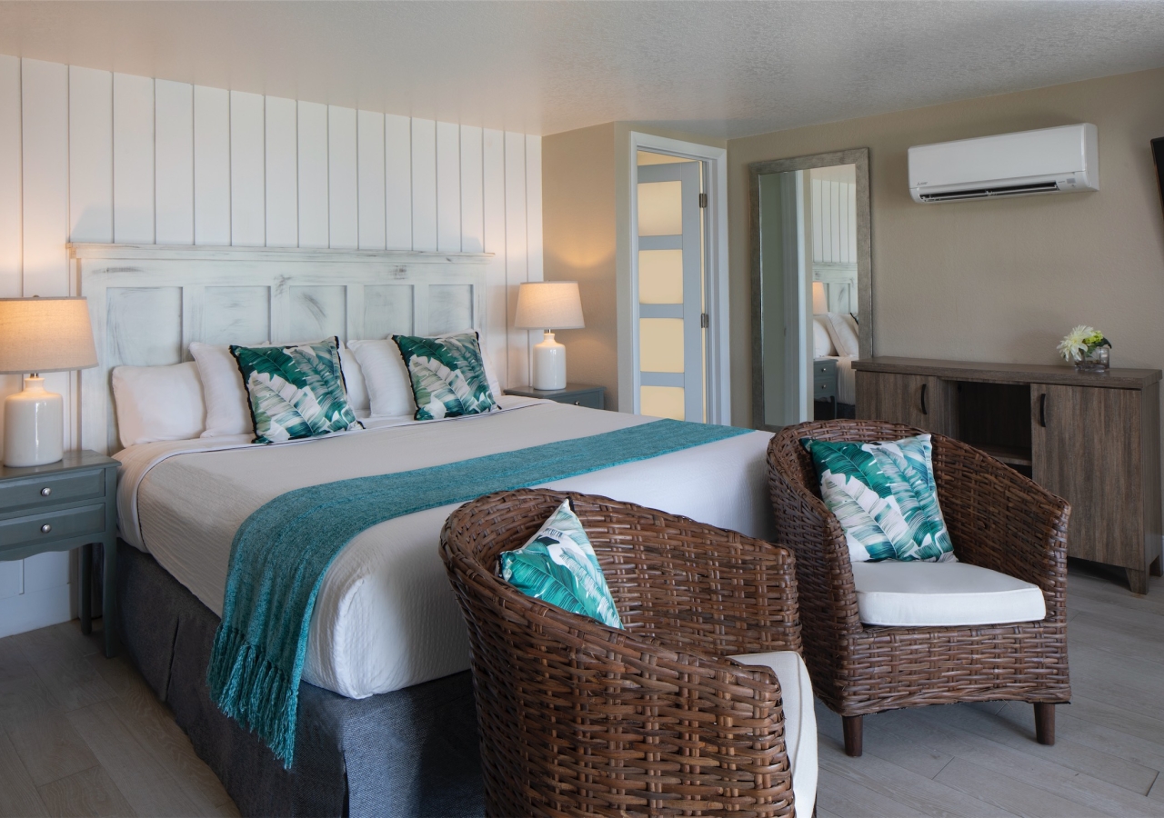 bedroom with two wicker chairs at the foot of the bed
