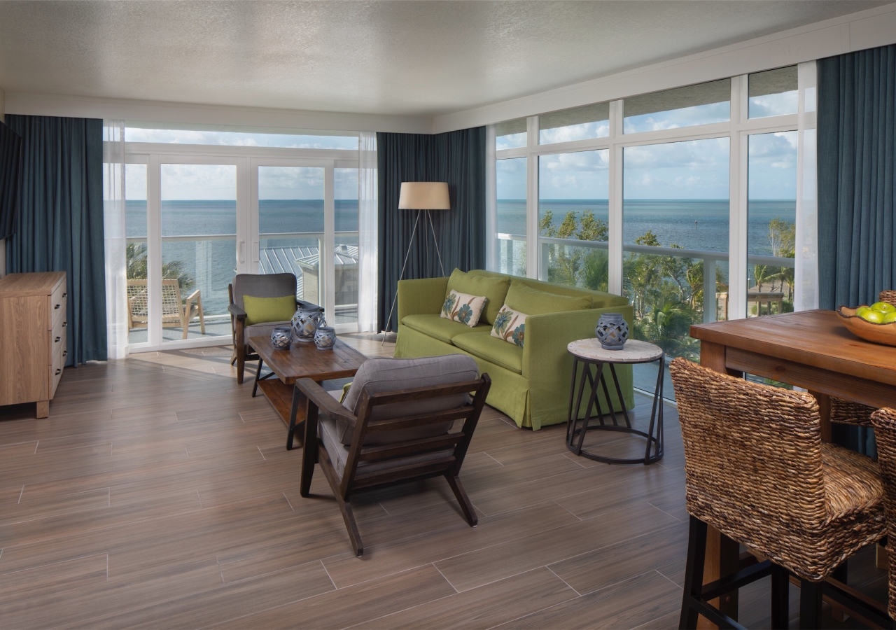 living room with lime green sofa and large floor to ceiling windows with view of the ocean