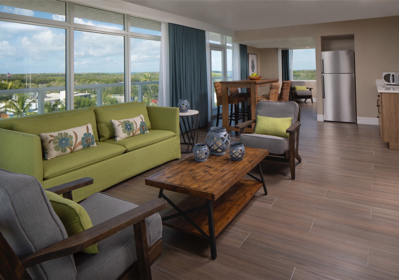 living room with lime green sofa and large floor to ceiling windows with view of the ocean