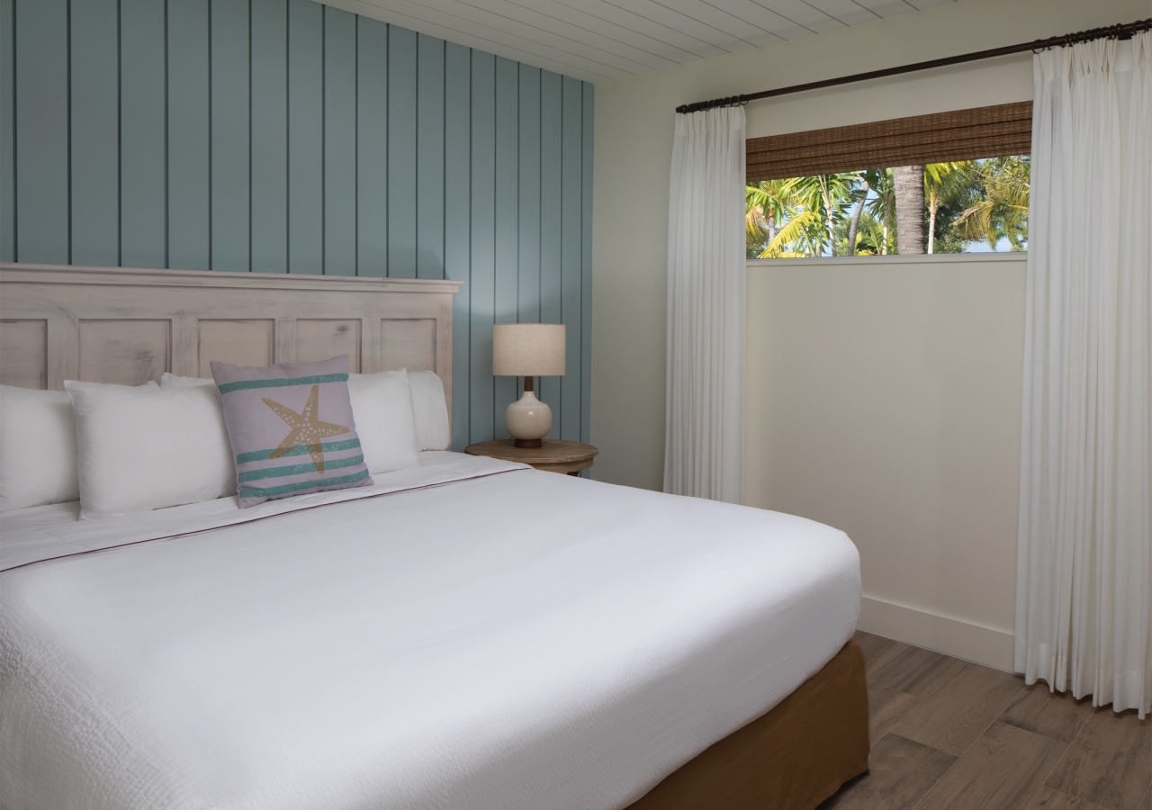 bedroom with small window and light blue wood panel accent wall