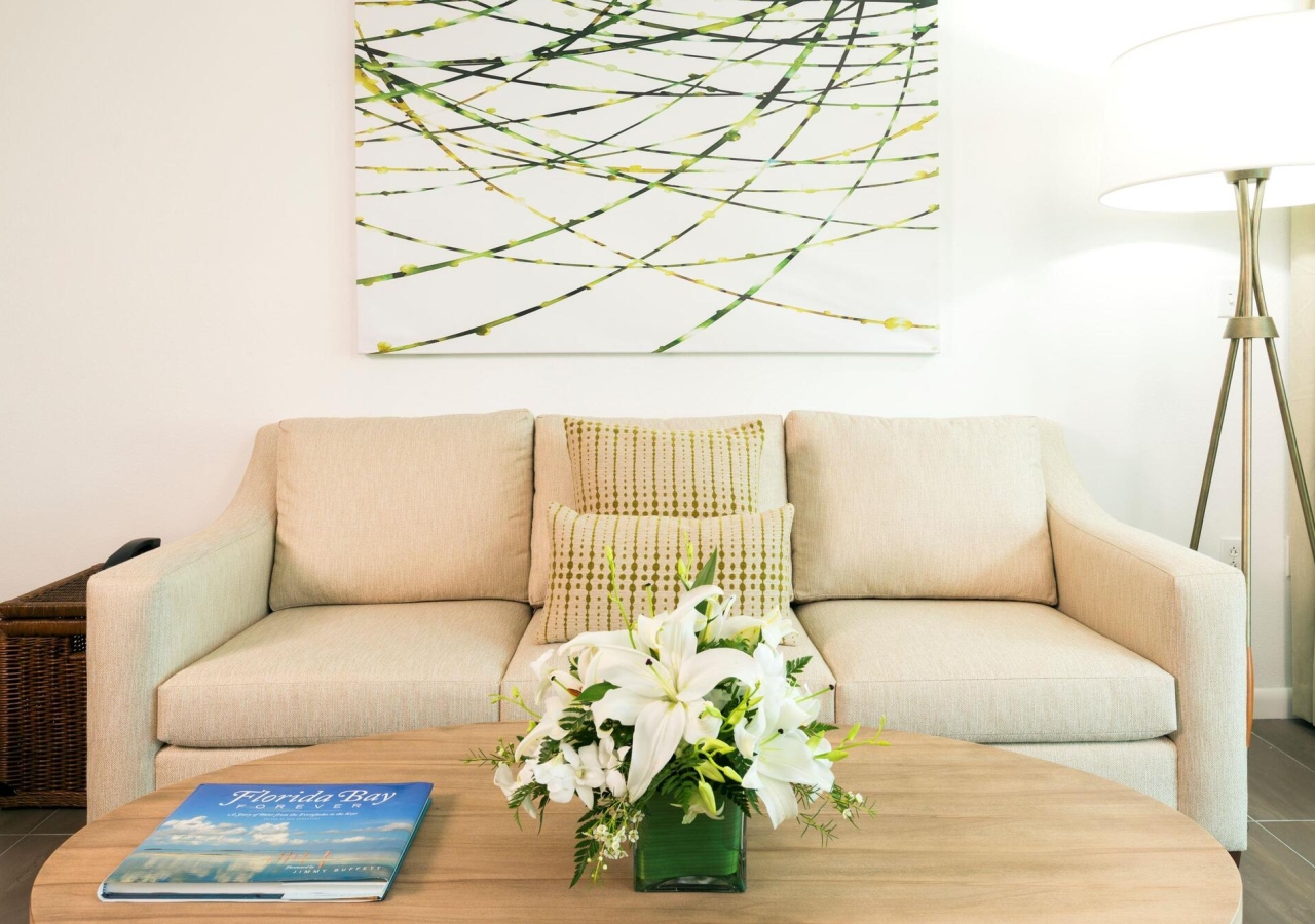 living room area with cream colored furniture and beautiful artwork