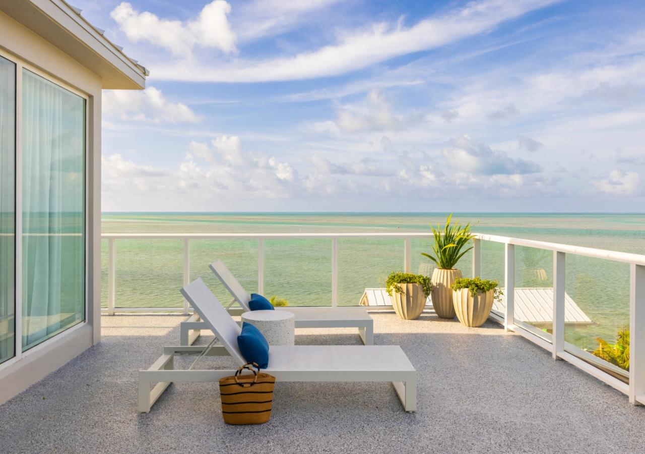Balcony view of the Three Waters Suite with ocean views and outdoor patio furniture.