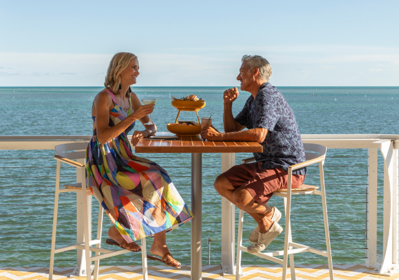A couple enjoying dinner with an ocean view.