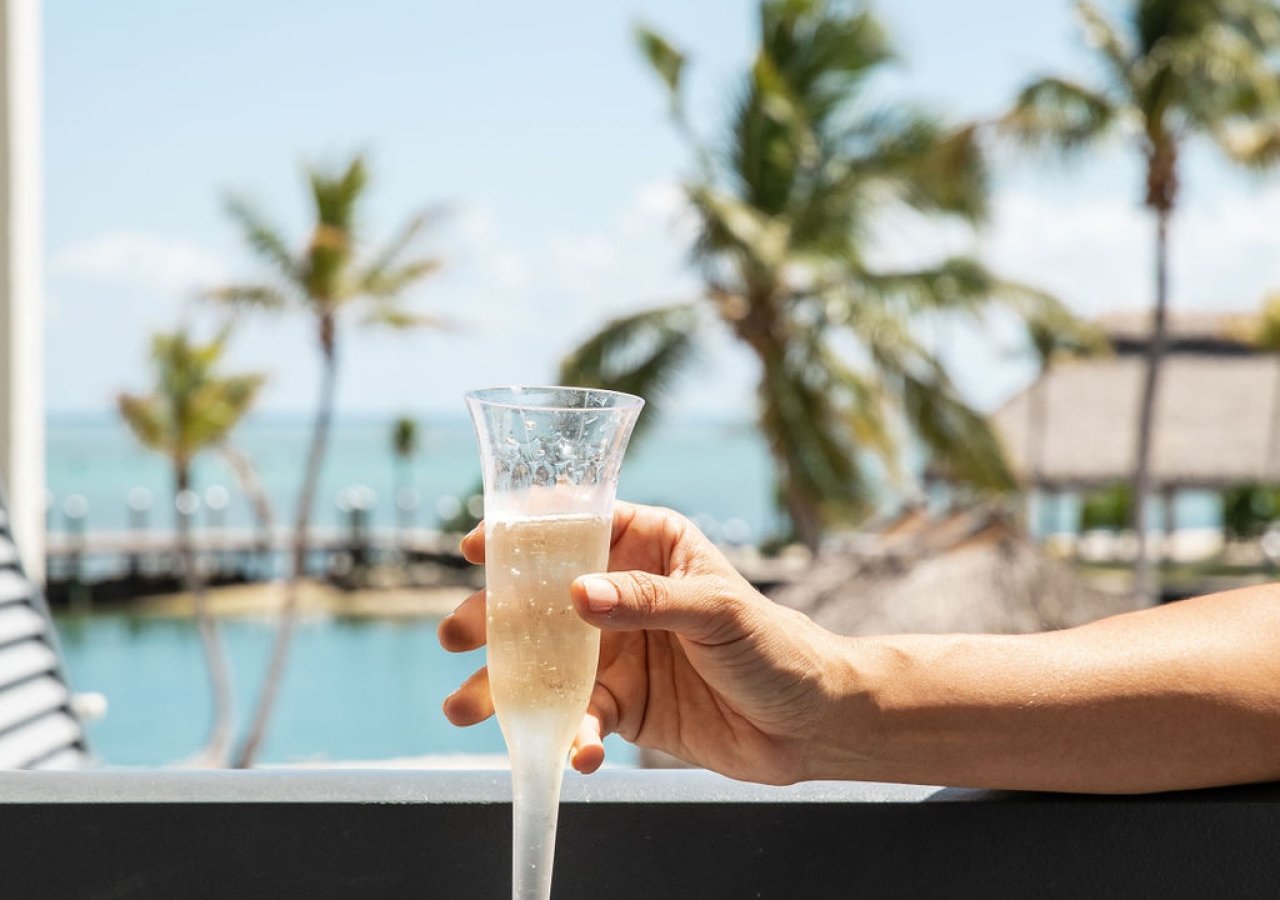 woman holding a glass of champagne overlooking the hotel pool