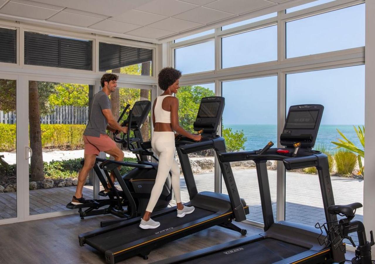 Two women walking on treadmills in a gym