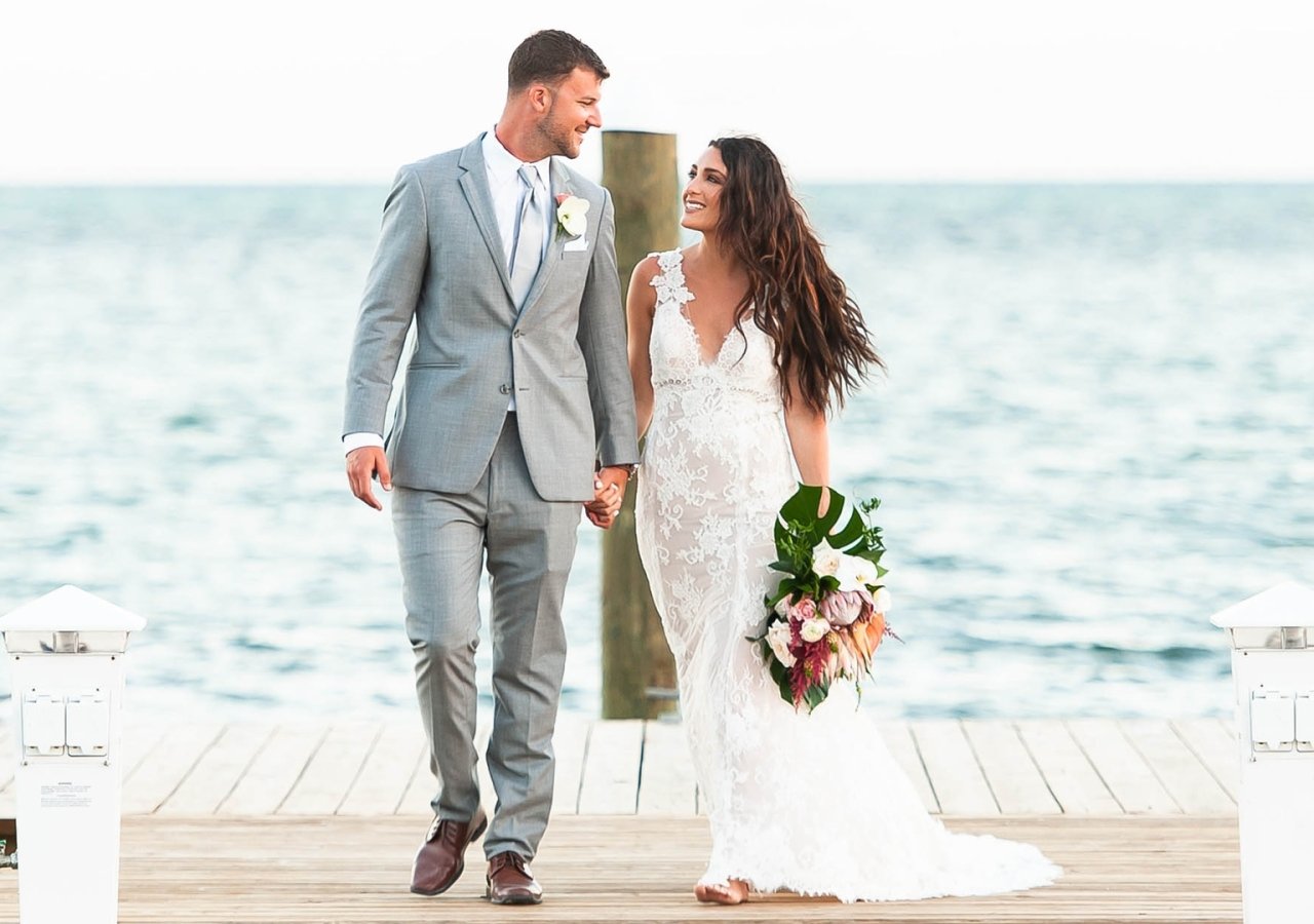 bride and groom on a pier into the ocean
