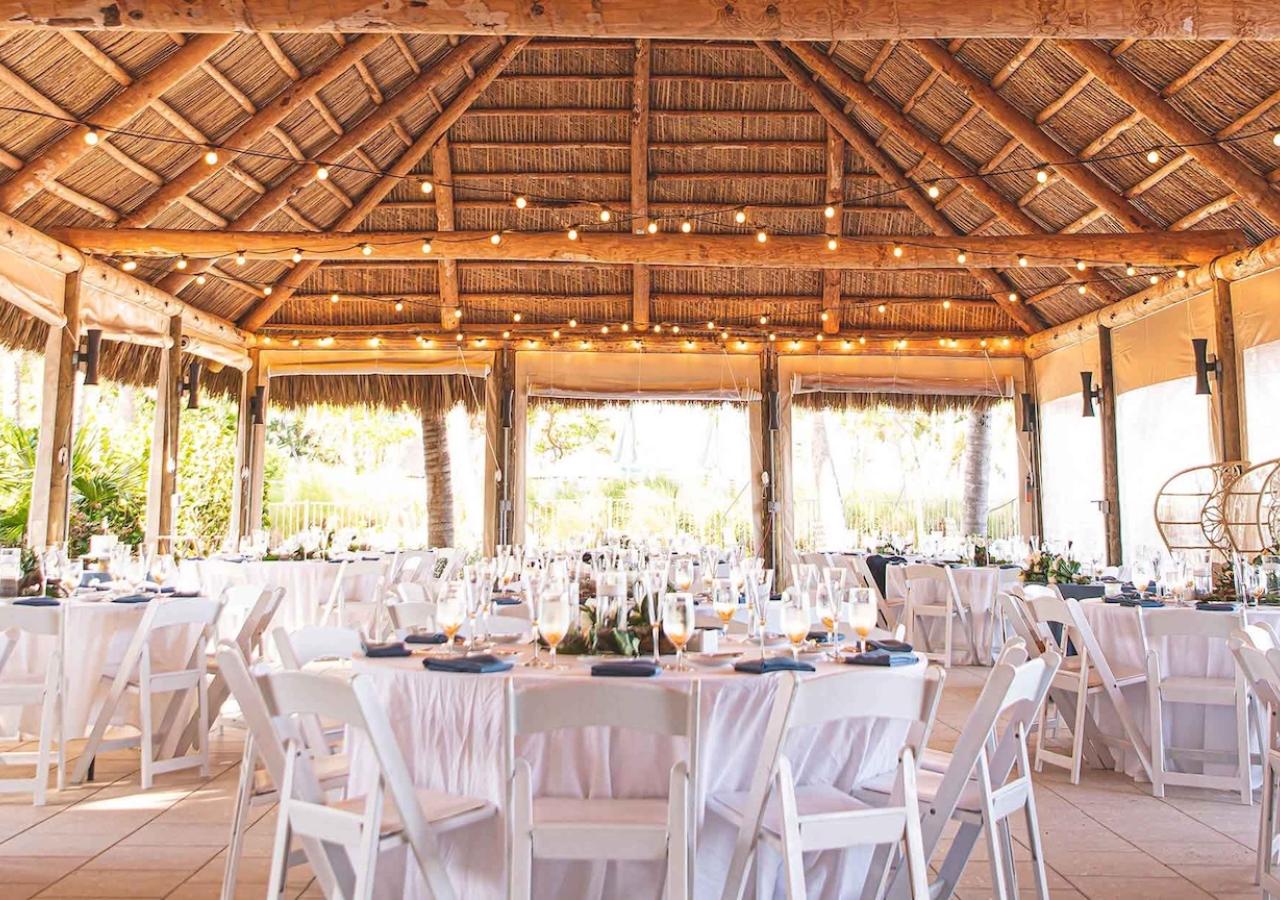 wedding tables set up for a wedding under a large tiki