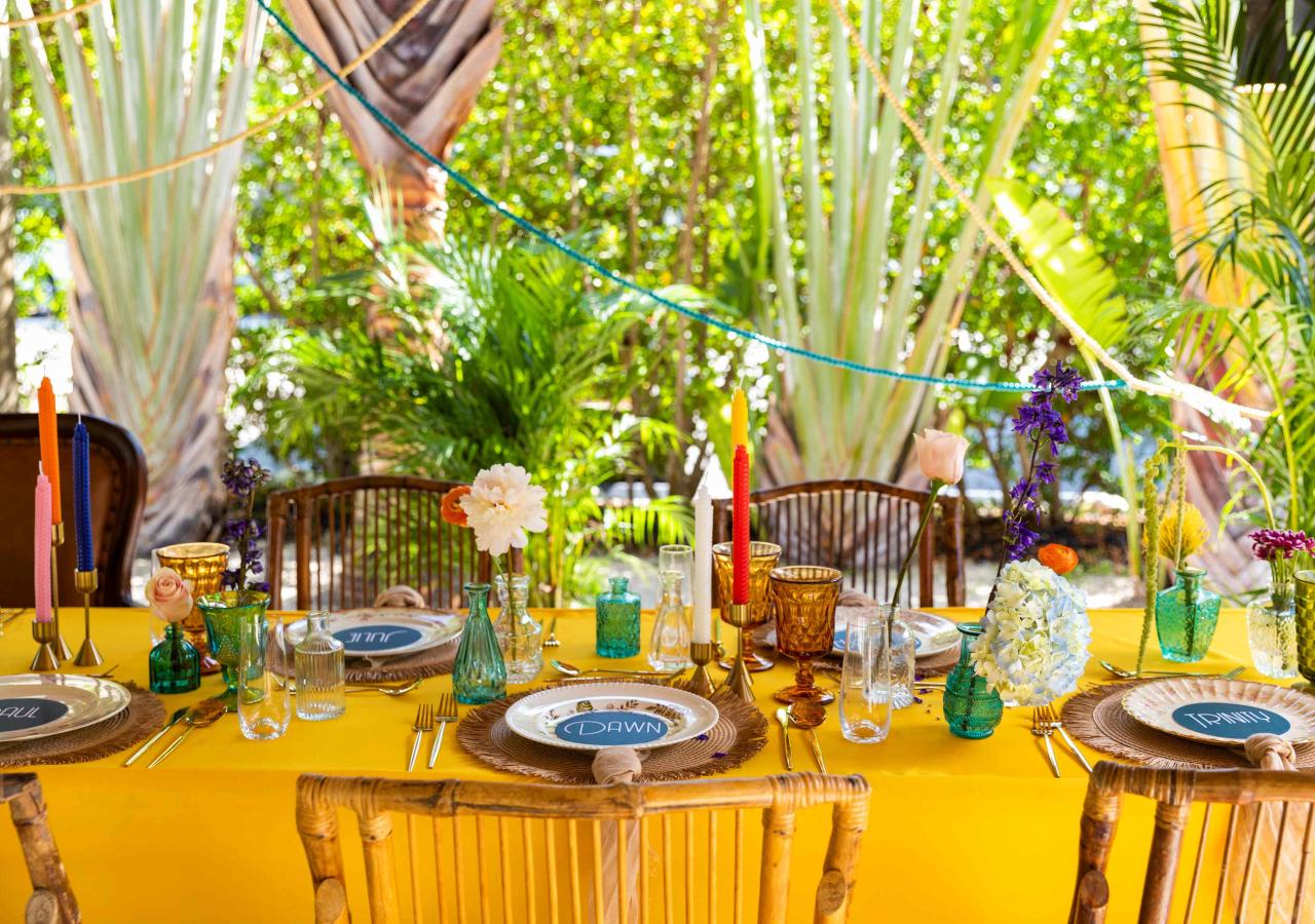 table set with colorful china and flowers for a wedding rehearsal dinner