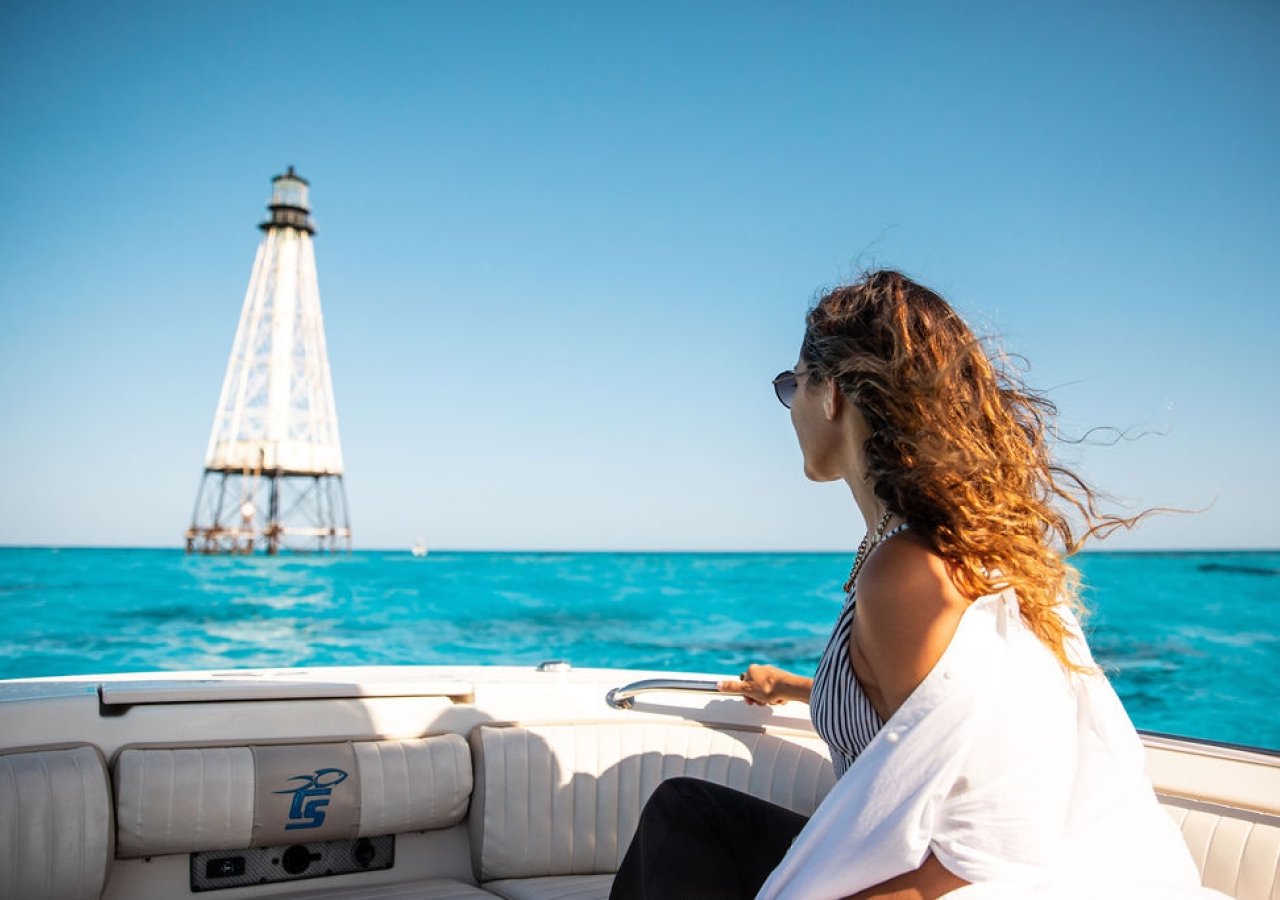 Woman on a boat looking at a lighthouse