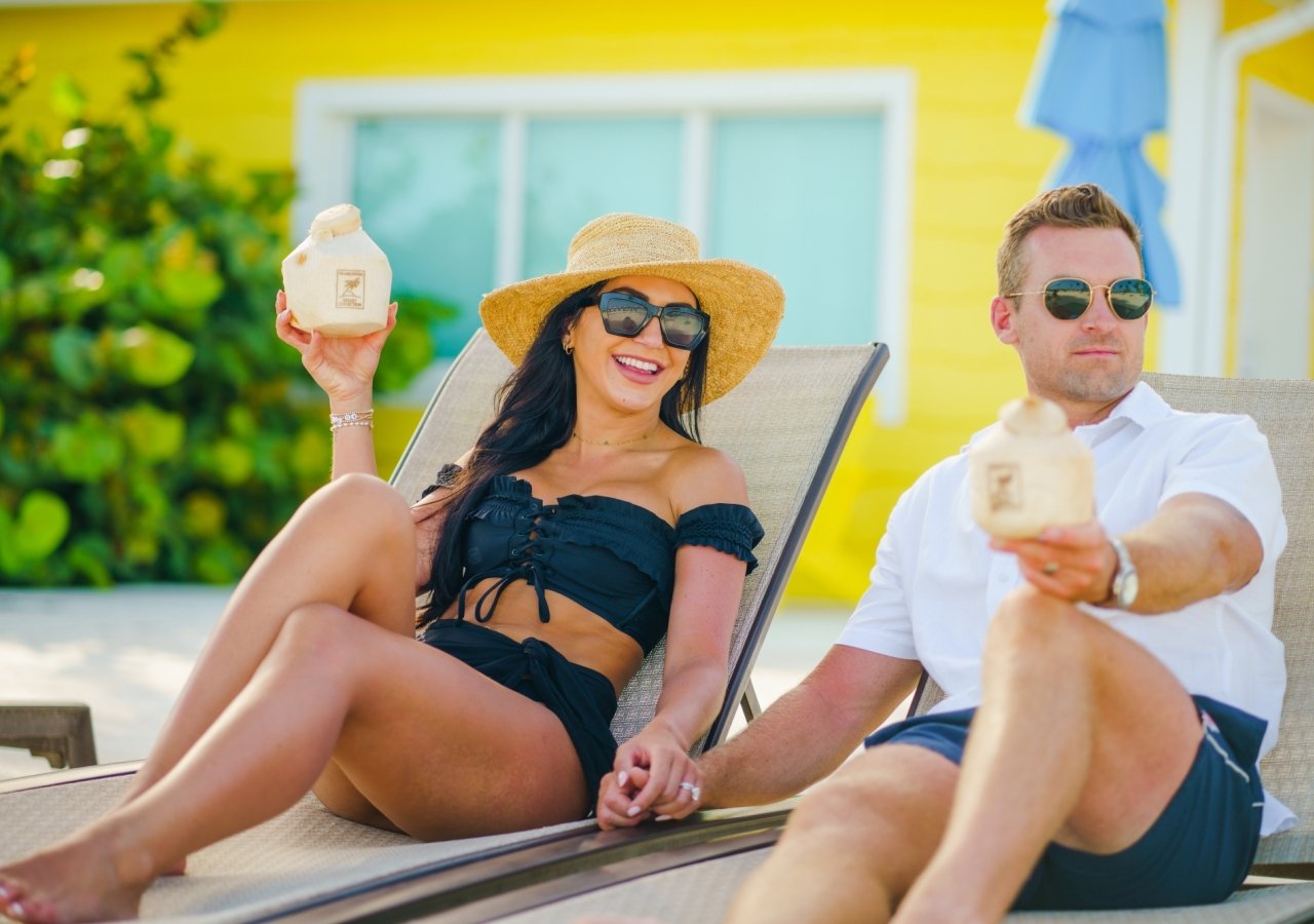 Couple having a drink and lounging on beach chairs