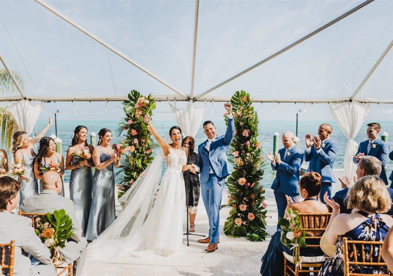 a bride and groom standing in front of friends and family