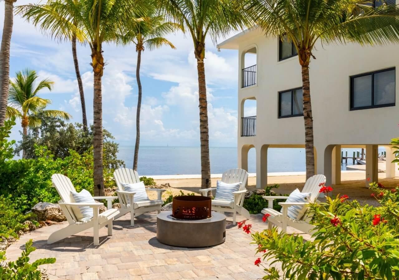 a fire pit outside a residence surrounded by tropical plants