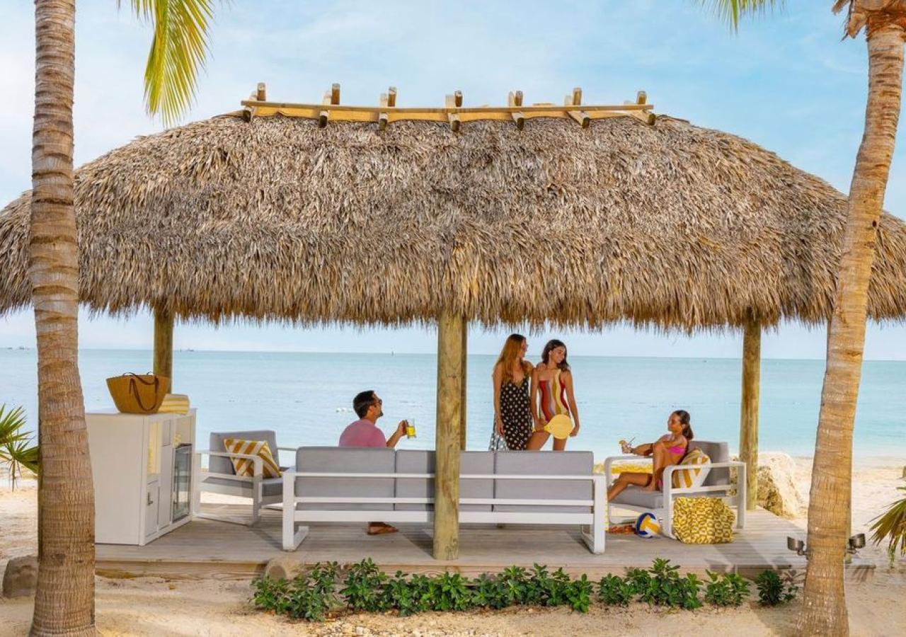 people gathering underneath a cabana at the beach